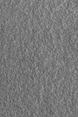 Gray porous cement wall with bumps. Coarse texture. Abstract colorless background for design and title.