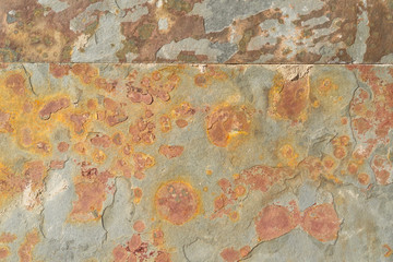 Wall stone tiles damaged by rust and peeling with corrosion. Smooth seams. Artistic abstract background for design and title.