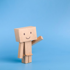 Funny toy cardboard robot on blue background