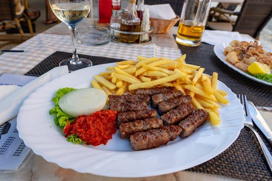 traditional croatian balkan cevapcici dinner with fies ajvar and onion