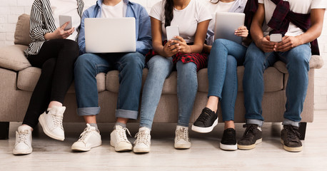 Internet addiction. Friends with gadgets sitting on sofa