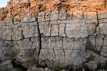 The curb erosion from storms. To indicate the layers of soil and rock.