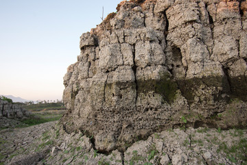 The curb erosion from storms. To indicate the layers of soil and rock.
