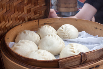 National Korean fast food ready to eat steamed vegetarian filling pies pyan-se in an open traditional wooden steamer with cover