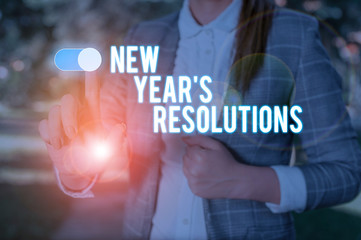 Text sign showing New Year S Resolutions. Business photo showcasing Wishlist List of things to accomplish or improve Woman wear formal work suit presenting presentation using smart device