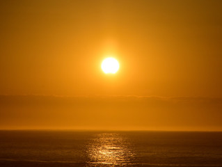 Sunset over the ocean between clouds