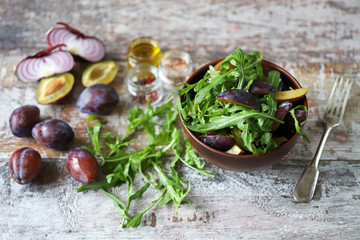 Light salad with arugula and plums. Autumn plum salad. Healthy food. Selective focus. Macro.