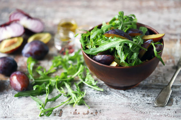 Light salad with arugula and plums. Autumn plum salad. Healthy food. Selective focus. Macro.