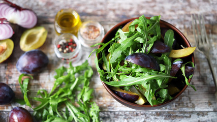 Light salad with arugula and plums. Autumn plum salad. Healthy food. Selective focus. Macro.