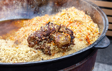 Traditional Uzbek pilaf in a large cauldron