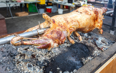 Cooking lamb carcass on a spit over hot charcoals