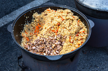 Traditional Uzbek pilaf in a large cauldron