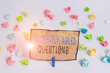 Text sign showing Frequently Asked Questions. Business photo text inquries that been informed more than one time Colored crumpled papers empty reminder white floor background clothespin