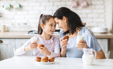 Mother and daughter having a bite in kitchen