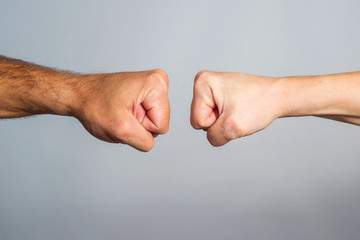 Two male fists hitting each other. Concept of confrontation, competition etc