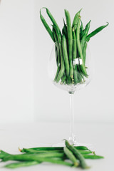 green beans in glass in front of white background