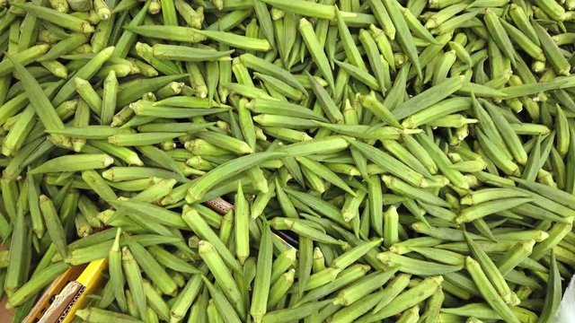A pile of okra, abelmoschus esculentus, for sale on a market stall