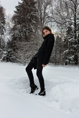 Lifestyle portrait of happy pretty young woman outdoors at snowing weather.