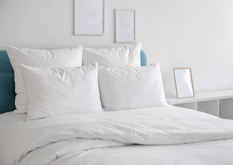White pillows and duvet on the blue bed. White pillows, duvet and duvet case on a blue bed. White...