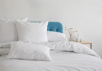 Foto op Aluminium White pillows and duvet on the blue bed. White pillows, duvet and duvet case on a blue bed. White bed linen on a blue sofa. Bedroom with bed and beddin.Front view © Vera