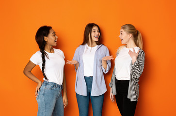 Excited teen girls talking and gossiping over background