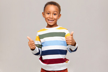 Positive human emotions, reaction and feelings. Emotional happy dark skinned boy in multi colored...