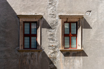 Fototapeta na wymiar Pair of windows on a dark gray plastered wall