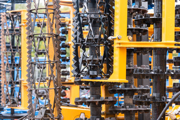 Agriculture machine detail in rainy day. Close up of steel parts, tubes, gears, wheels, tires, hydraulic system with raindrops.