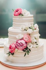 Appetizing big fresh pastry cake covered by white cream icing and decorate sweet flower serving on...