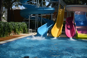 Little girl on water slide at aquapark during summer holiday