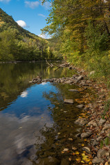 Fototapeta na wymiar River in Cornwall, New England in early fall showing reflections of deep blue fall sky