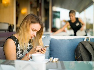 Girl with a smartphone in a summer cafe