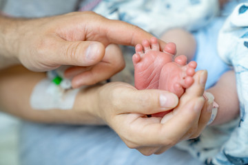 Stopy noworodka w dłoniach rodziców