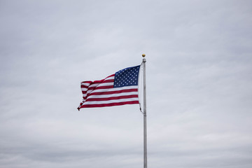 American flag flying from pole on overcast day