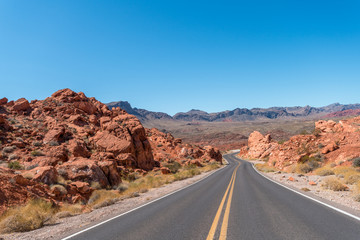 Two Way Highway Crossing Large Red Sandstones Rocks with Clear Skies
