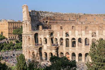 Naklejka premium FLAVIAN THEATRE, ROME, ITALY - 2018: Many people gather at the Colosseum entrance at sundown.