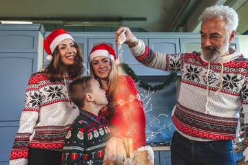 Happy family gathered on Christmas day while pouring sugar on pandoro