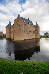 Fototapeta premium Medieval European Brick Castle with Large Moat and Later Renovations
