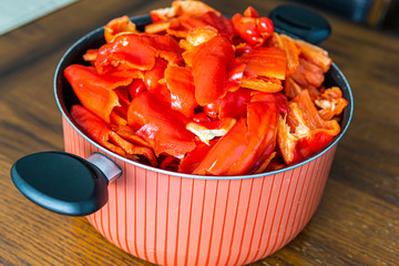 Cut Red Bell Peppers in a pot on a kitchen table