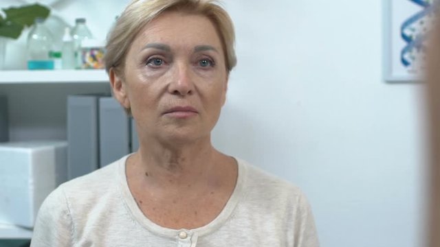 Shocked senior woman crying, listening to doctor in hospital, bad health news