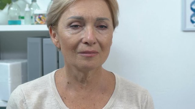 Compassionate senior lady crying slow-mo, suffering emotional pain, feeling hurt