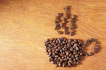 coffee cup shape of roasted coffee beans on wooden background
