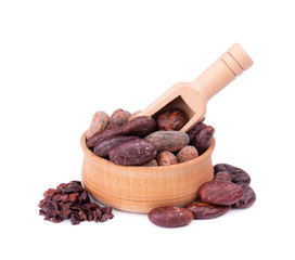 Peeled cocoa beans in the wooden bowl, isolated on white background. Roasted and aromatic cocoa beans in wooden spoon, natural chocolate.