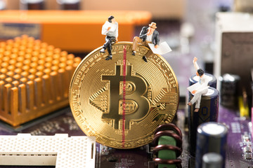 miniature business men sitting on bitcoin with red mark line for halving concept