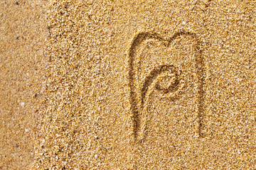 Closeup image of thai letter khaaw khon meaning people written at yellow beach sand background.