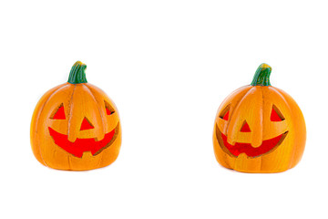 Two orange ceramic pumpkins with nose eyes and mouth red isolated on a white background.