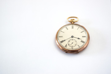 Gold pocket watch on white paper.