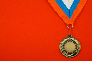 Gold medal with ribbon on red background