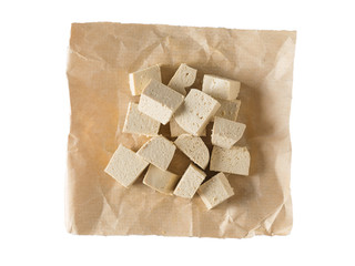 Pieces of tofu cheese on paper isolated on white background. Flat lay.