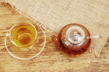 Cup of tea and teapot on rustic background